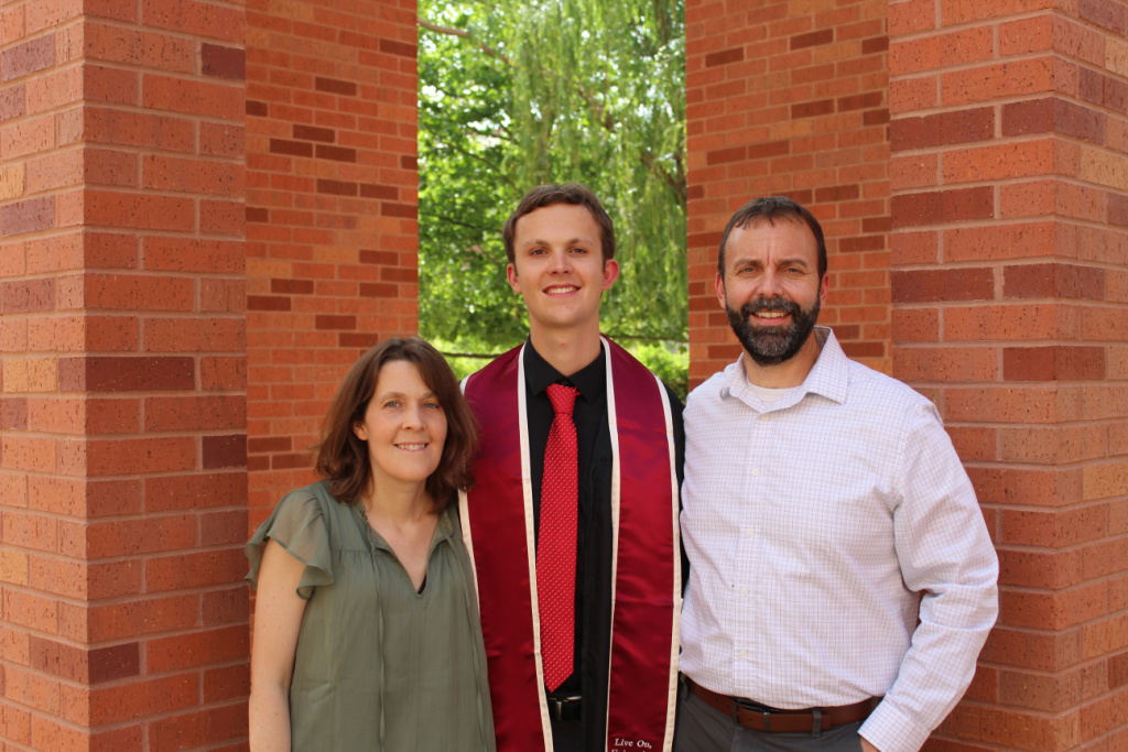 a mom, son and dad at a college graduation. 