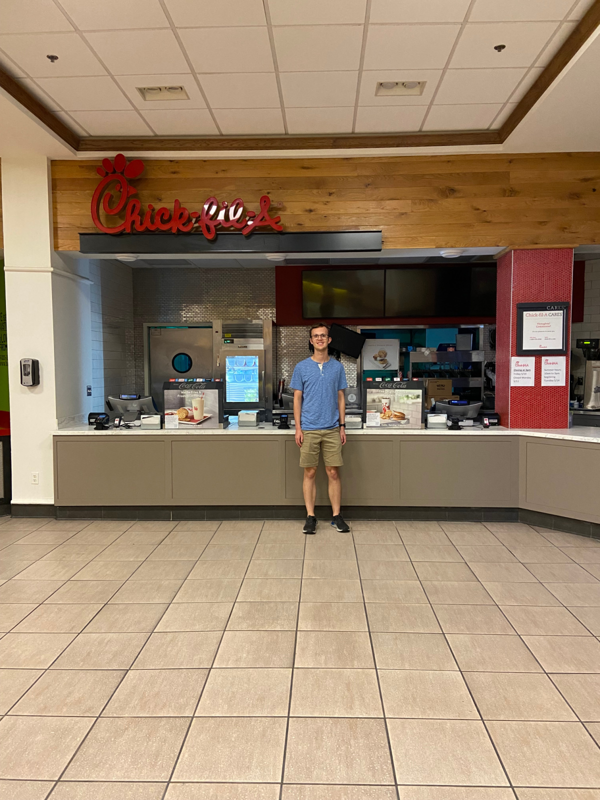 man standing next to chick fil a. 