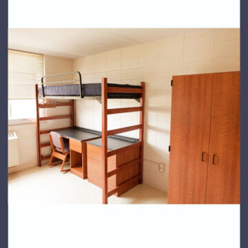 dorm room with a bunk bed and desk and dresser.