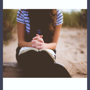 girl sitting with a Bible, praying.