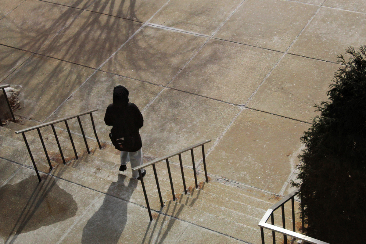 student walking on campus on stairs. 